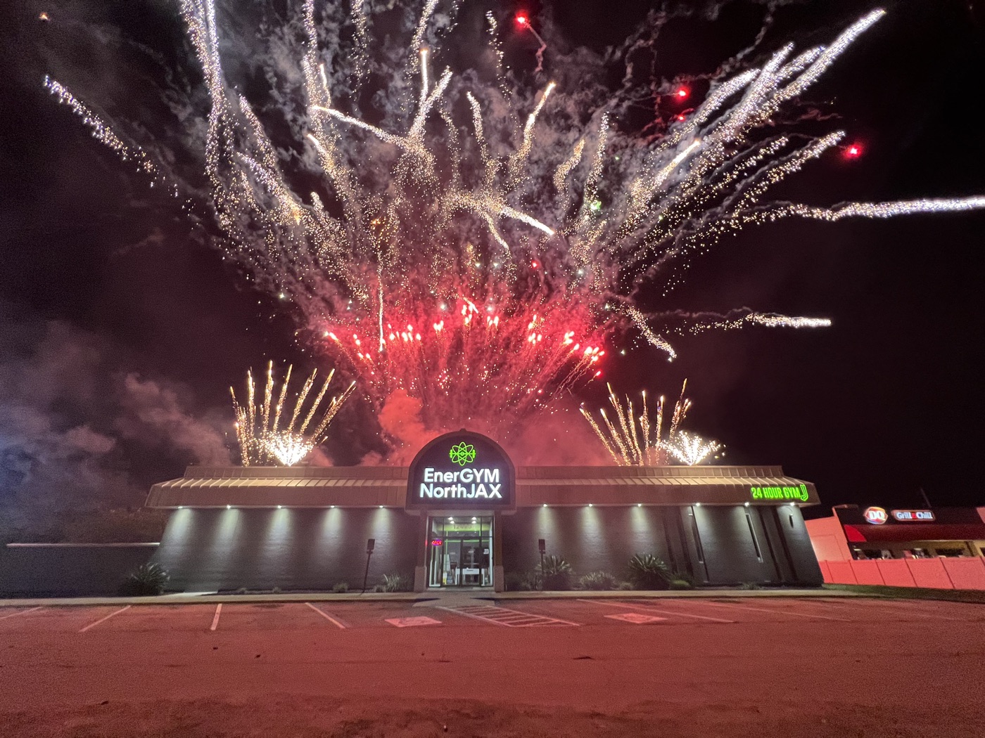 Red and white fireworks over an evening commercial venue